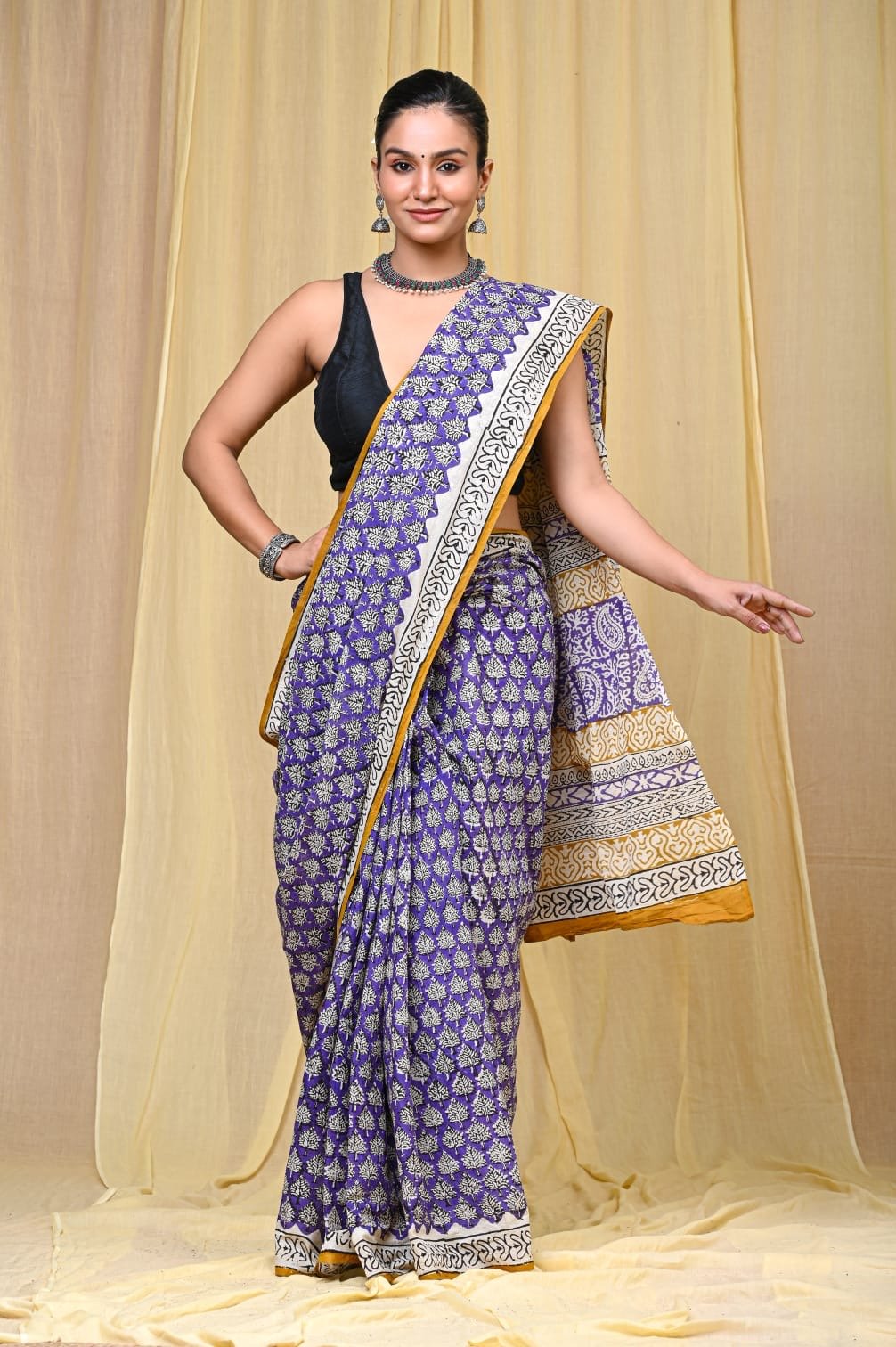 Purple saree with floral motifs and a decorative border design