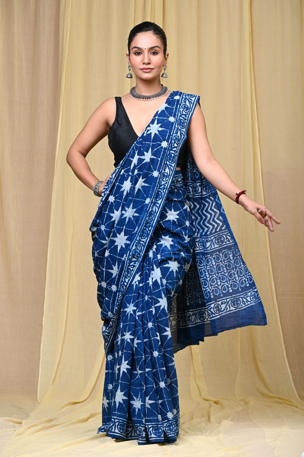 Indigo saree with star motifs and geometric border design in traditional Bagru print
