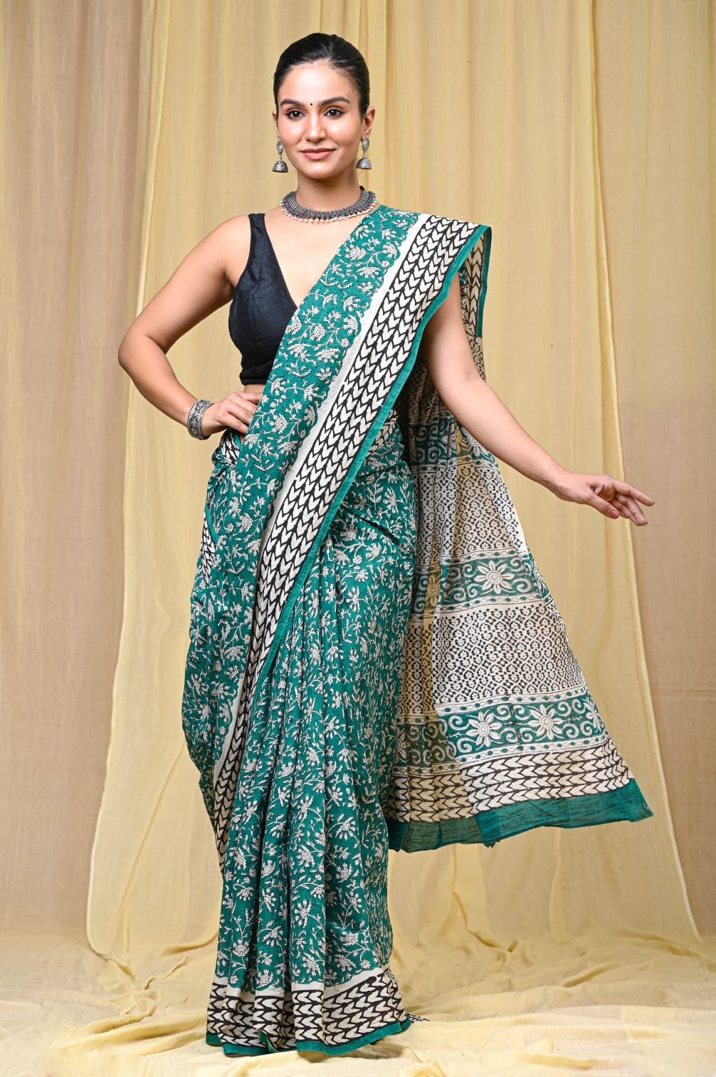 Teal saree with floral motifs and black-white border design