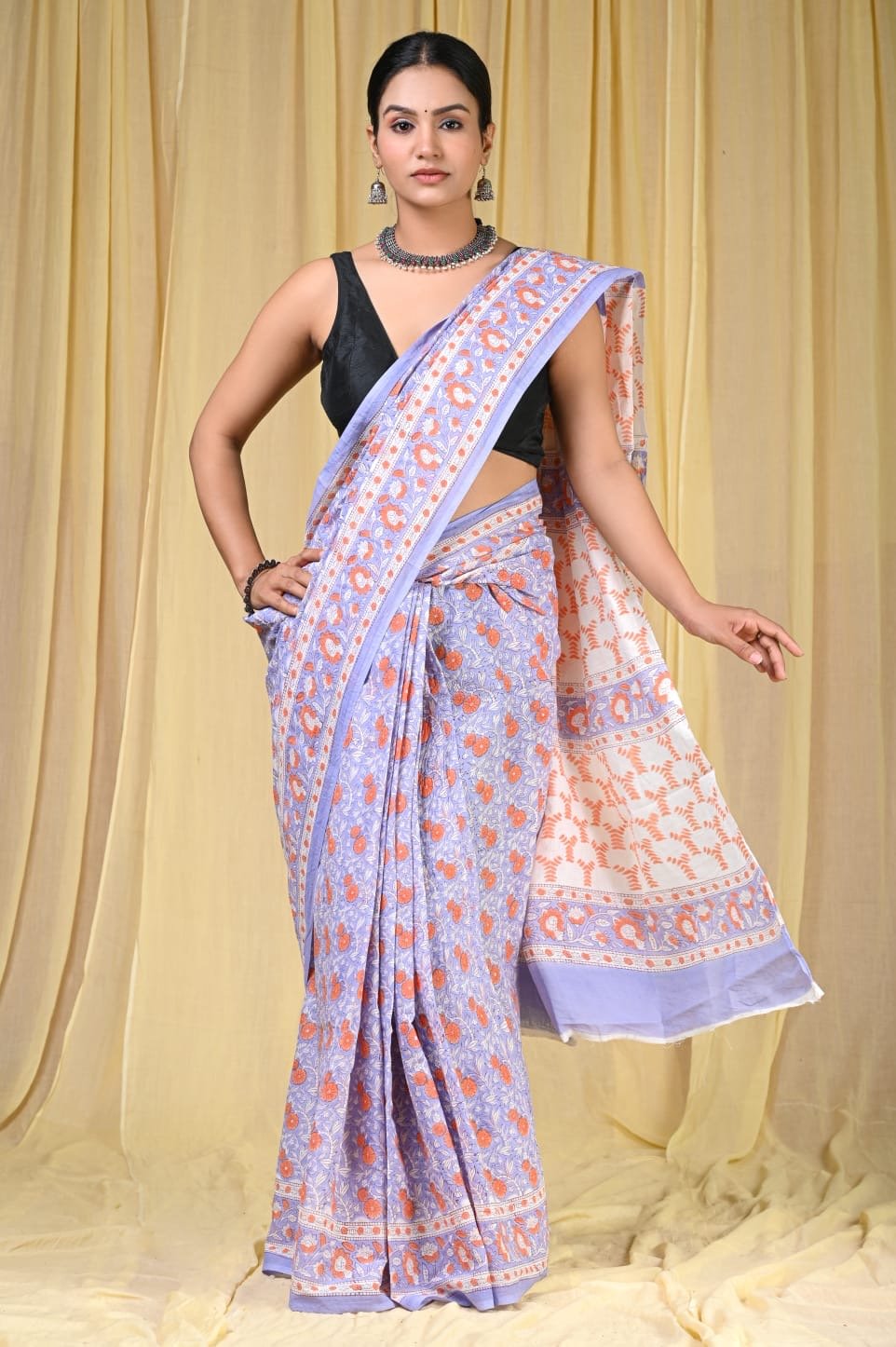 Lavender saree with orange floral motifs and intricate border design