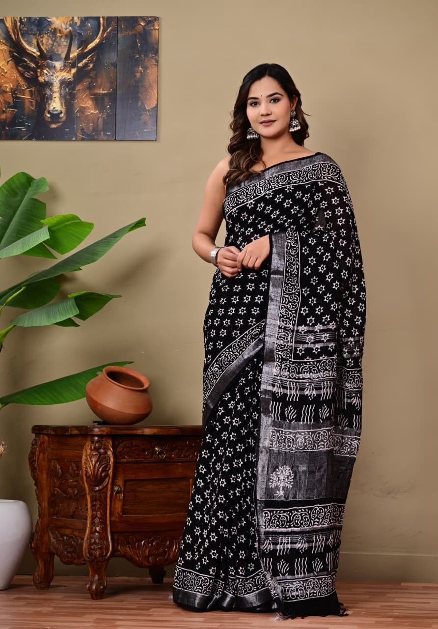A black saree with white floral Bagru hand block print and geometric border motifs.