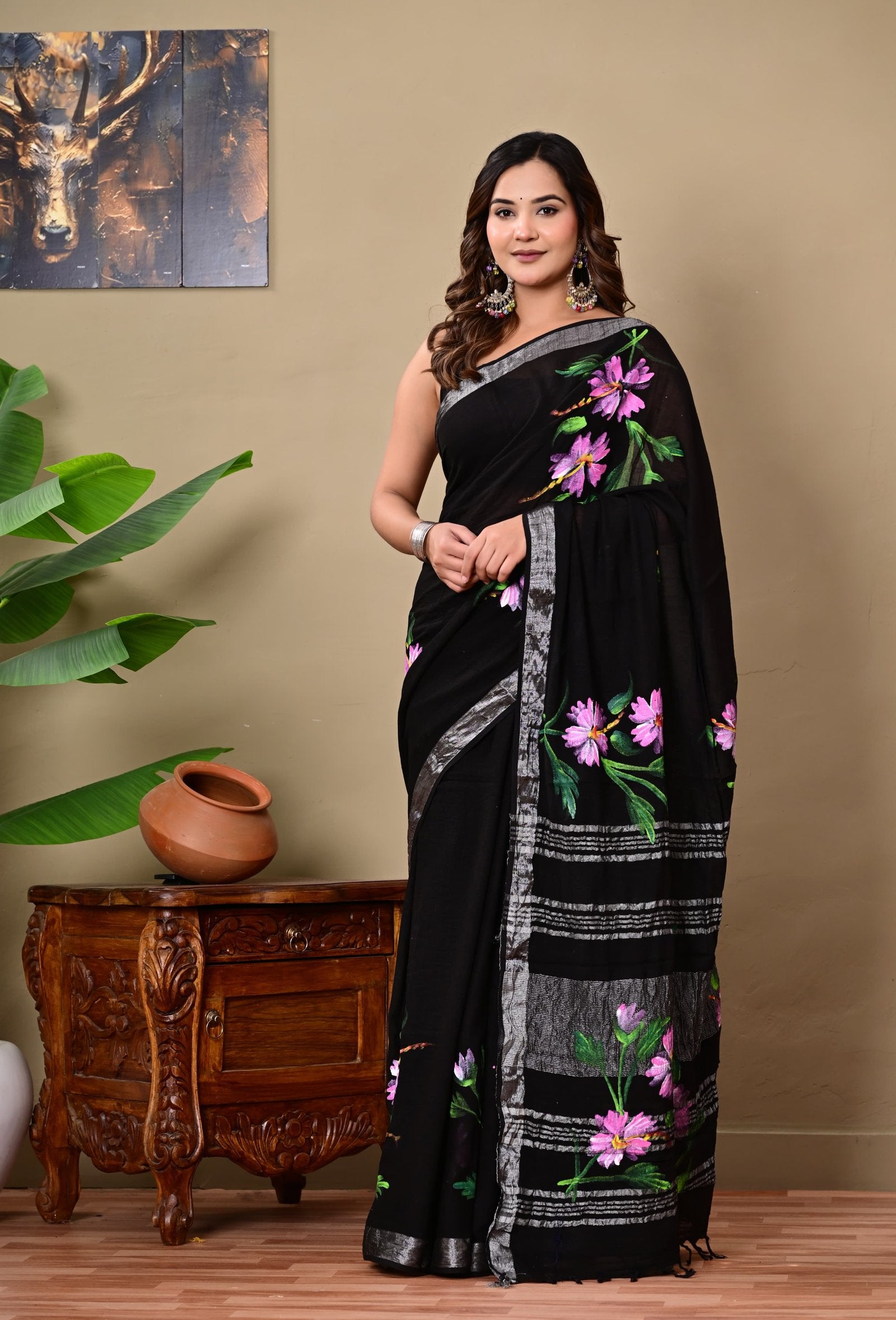 Black saree with vibrant purple and green floral motifs, silver borders