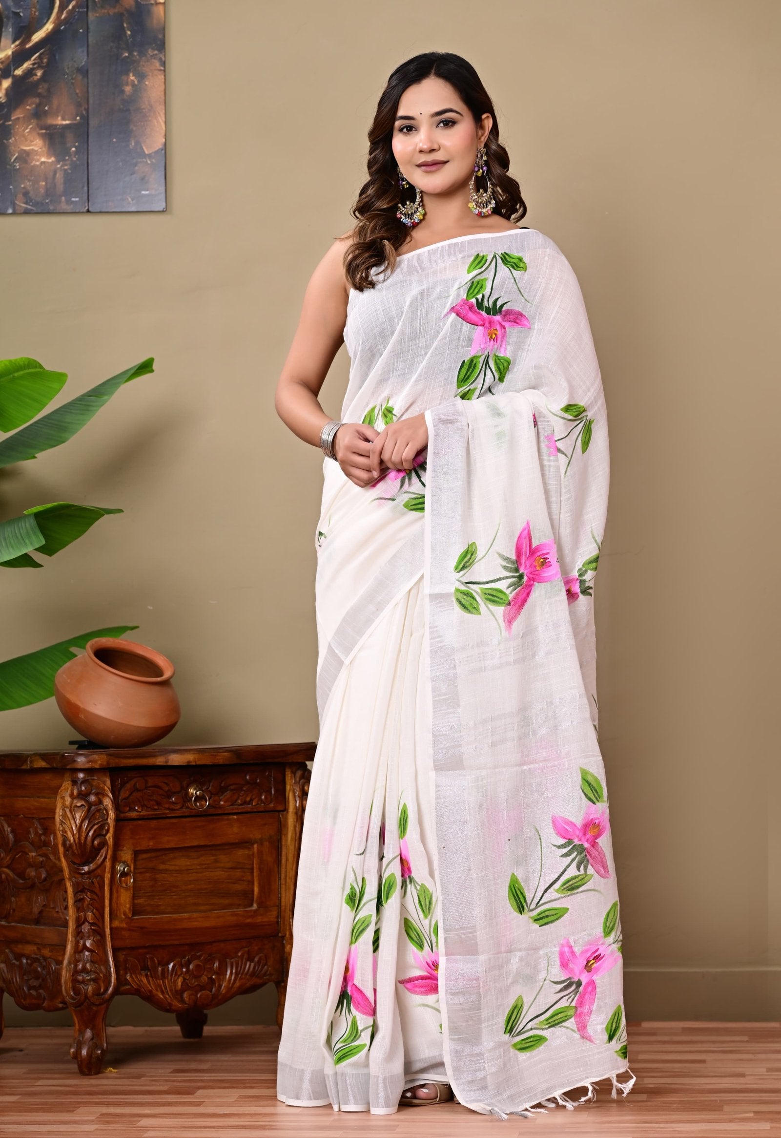 White linen cotton saree with vibrant pink floral motifs and green leaves