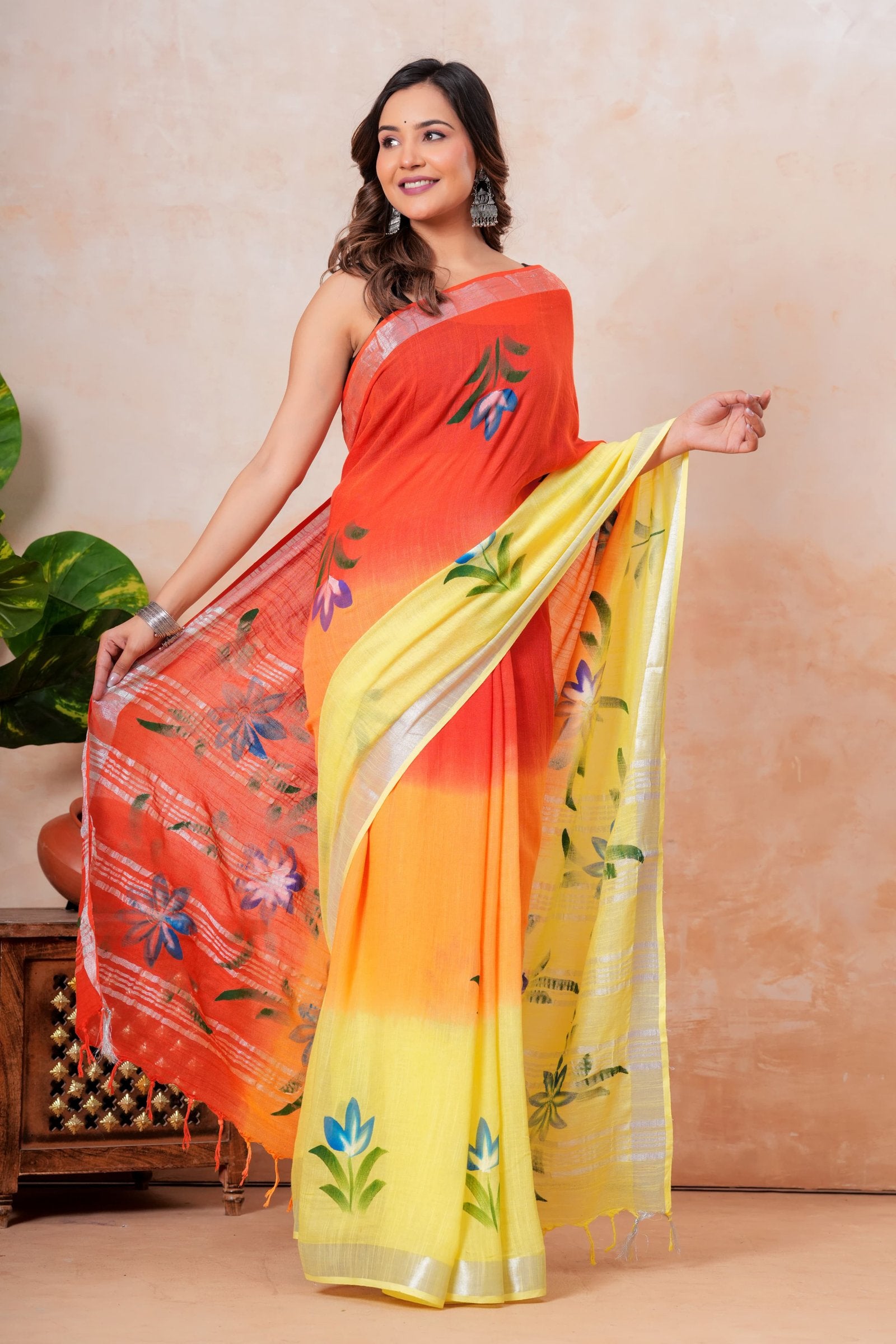 Vibrant sunset yellow and orange saree with floral motifs and natural texture