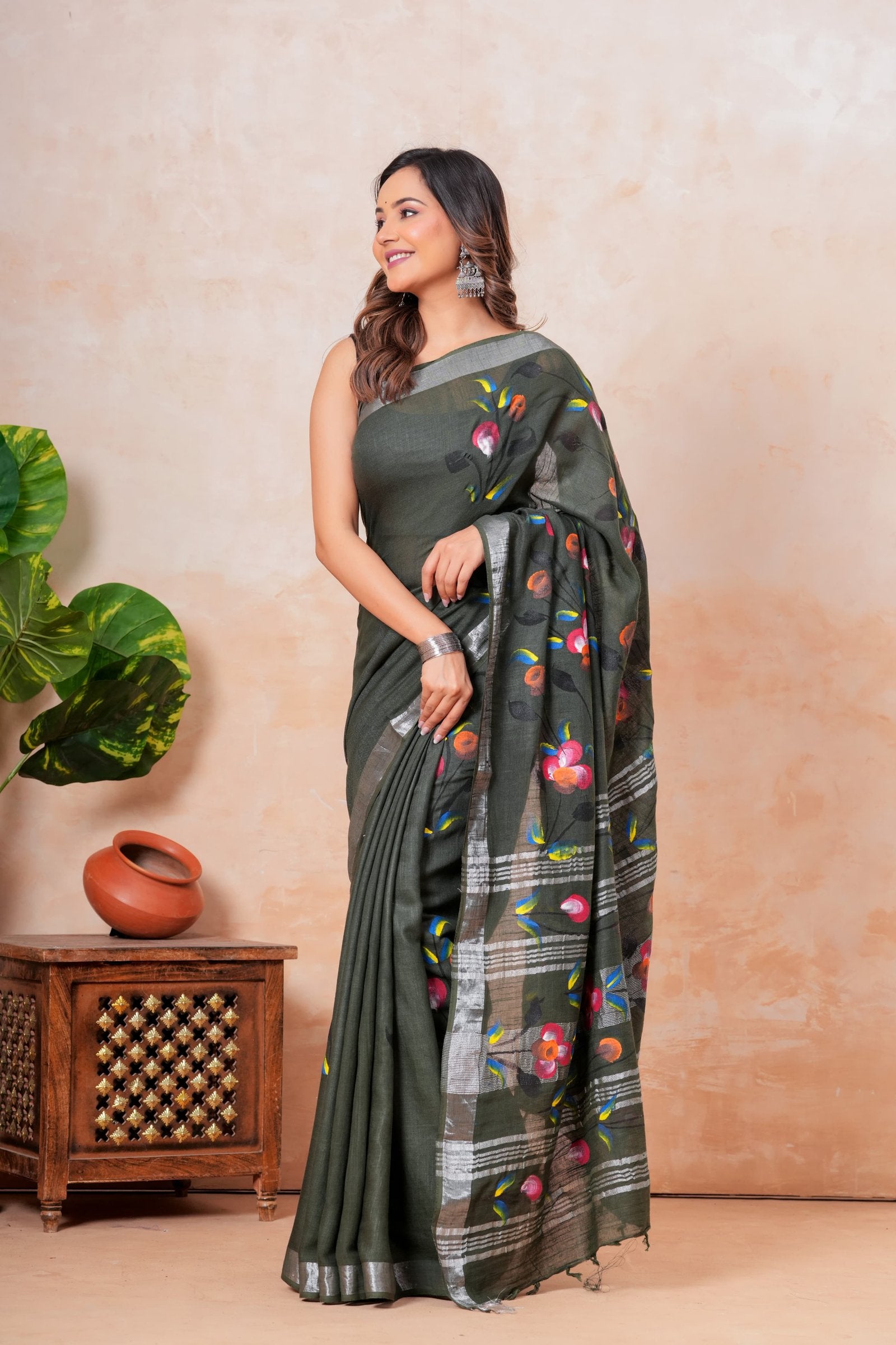 Olive green saree with floral motifs and linen texture