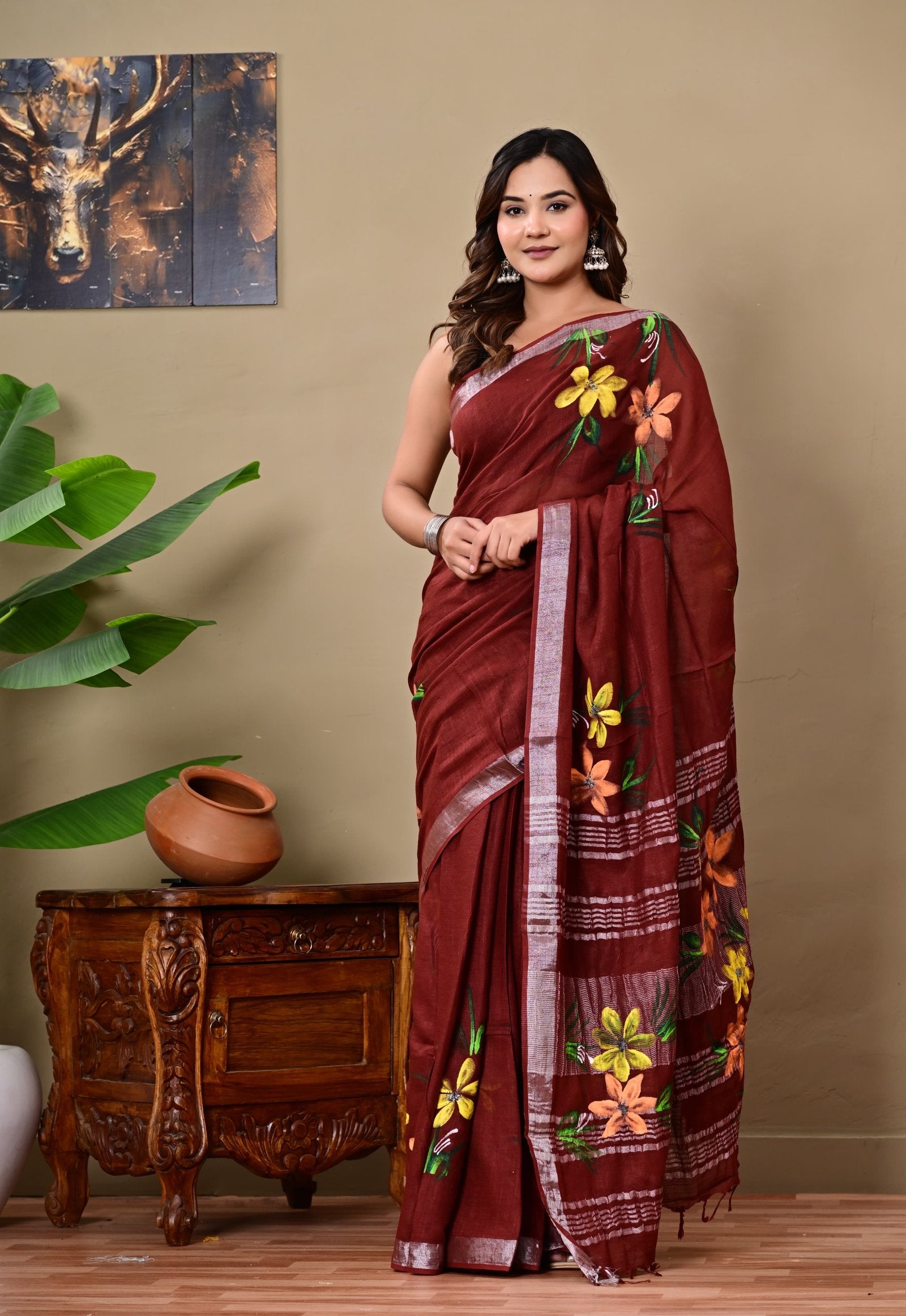 Maroon saree with vibrant floral motifs and silver borders, hand block printed.