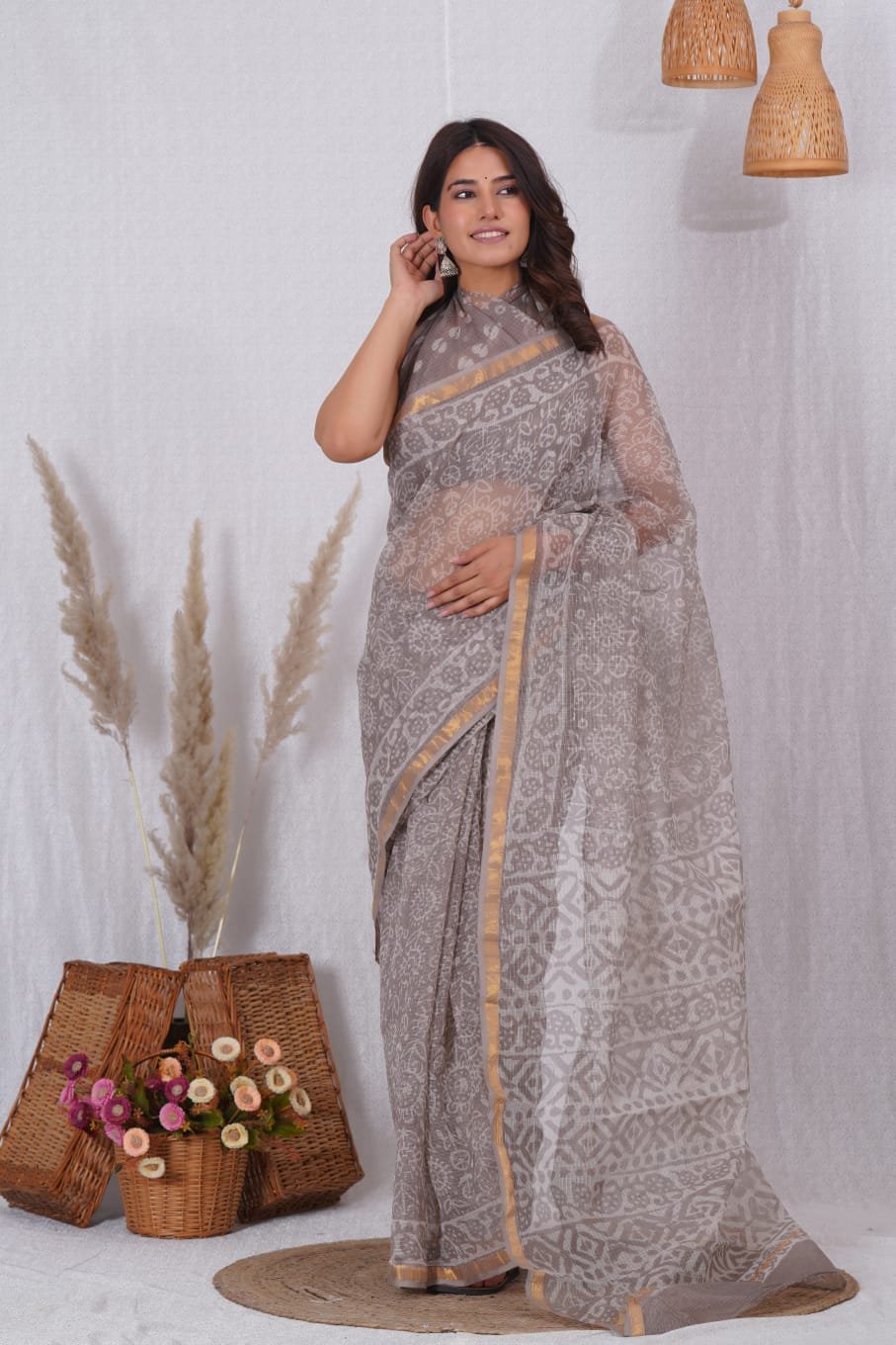 Grey Kota Doriya saree with floral Bagru print and gold border.