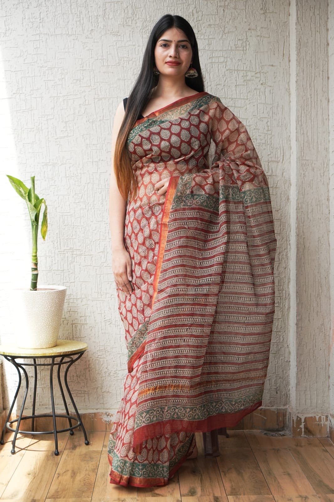Rust red saree with floral motifs and intricate border design