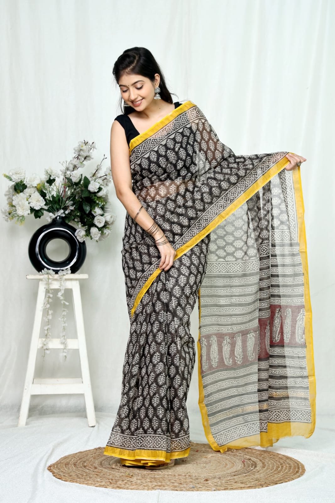 Black saree with floral motifs, yellow border, geometric pattern