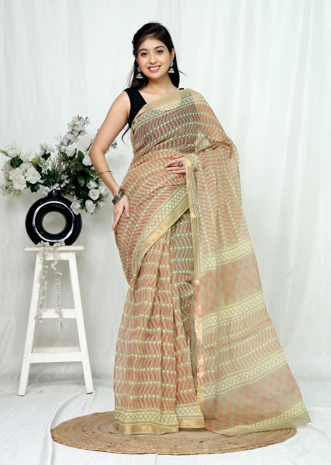 Pastel green and red floral motifs on a Kota Doriya saree with geometric patterns
