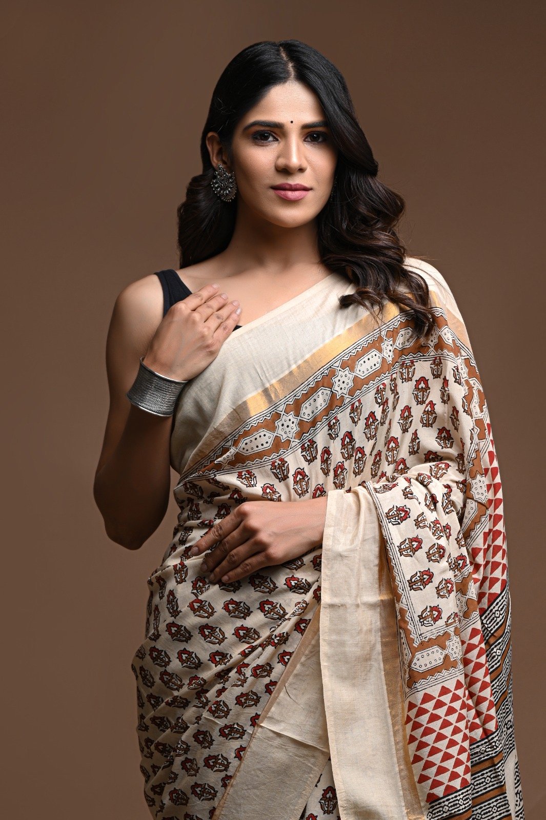 Beige and red saree with floral and geometric motifs