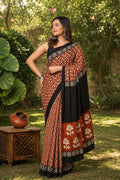 Rust saree with floral motif, black border, Bagru hand block print