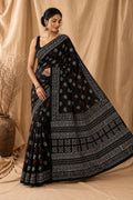 Black saree with white and red floral motifs, intricate border design