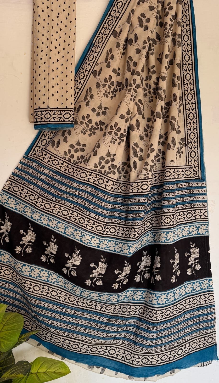 Beige and black saree with floral motifs and intricate border design