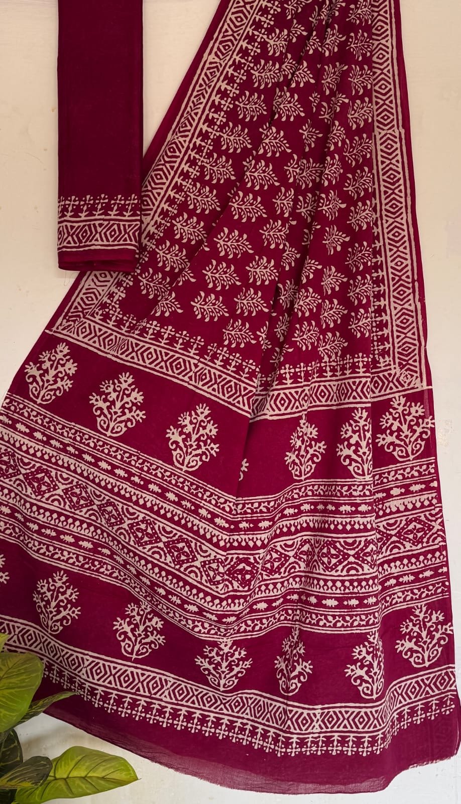 Maroon saree with white floral motifs and traditional patterns