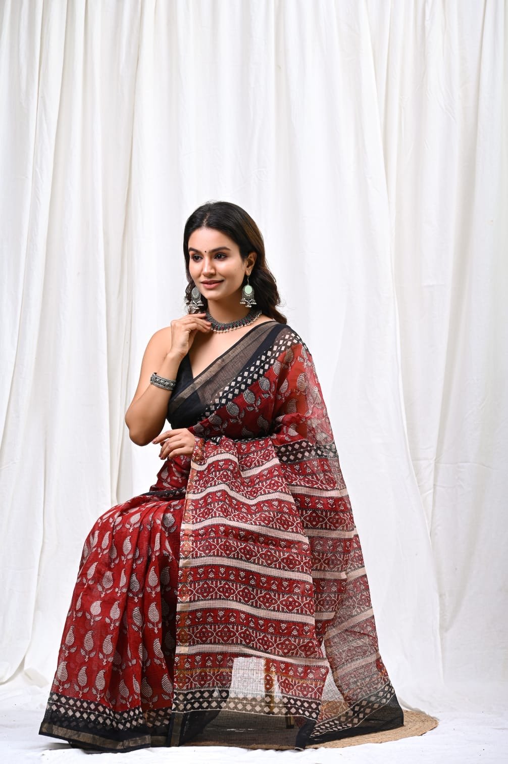 Red saree with floral motifs and black border in Bagru hand block print