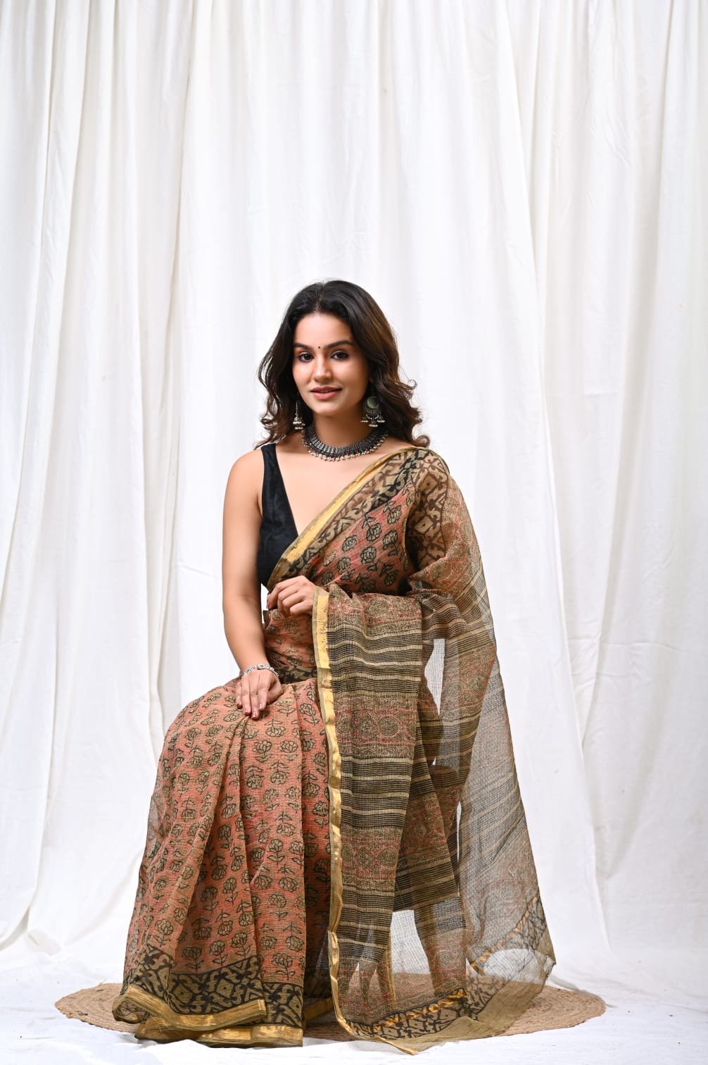 Rust saree with floral block print and traditional border