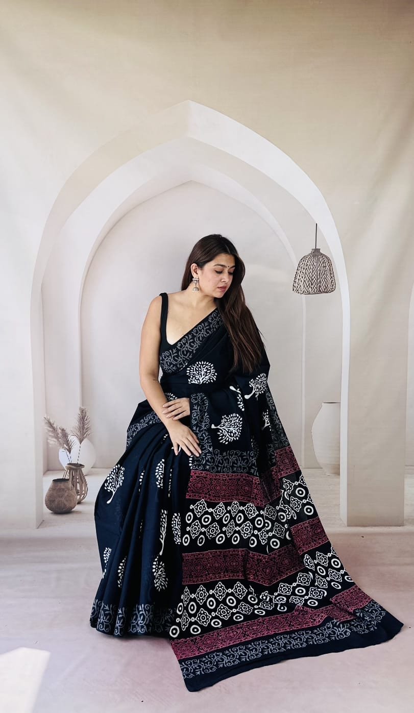 Navy saree with white floral and geometric patterns, red border accents