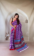 Purple saree with floral motifs, red border, and intricate pallu design in red and blue