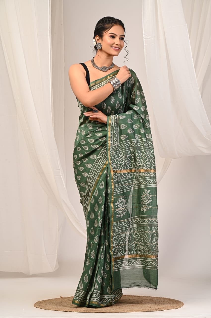 Green saree with floral motifs and golden borders, hand block printed.