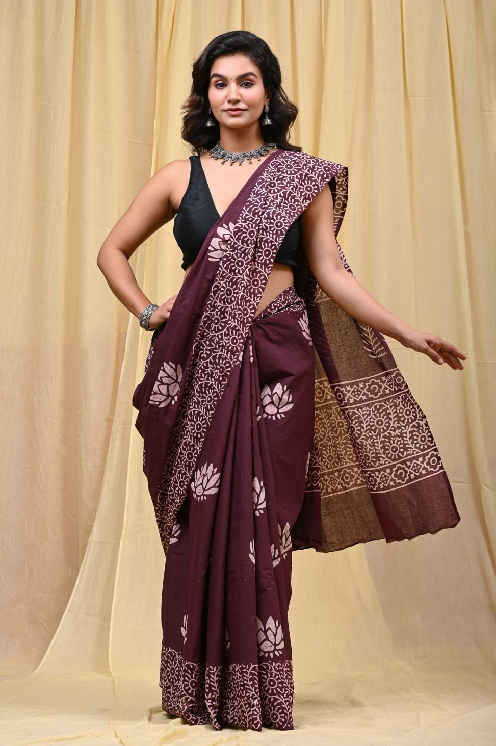 Maroon saree with lotus motifs and intricate border pattern