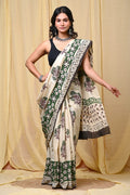 Cream and green saree featuring floral motifs and geometric border in Bagru hand block print
