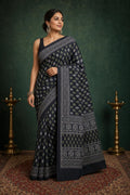 Navy saree with white and green floral motifs and decorative borders