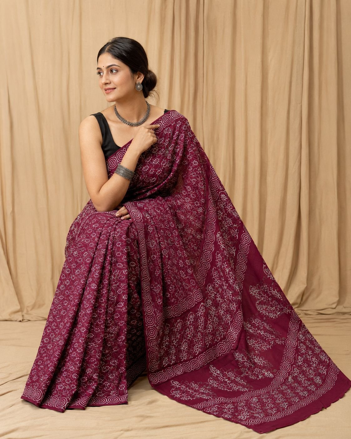 Maroon saree with floral motifs and swirl border in Bagru hand block print